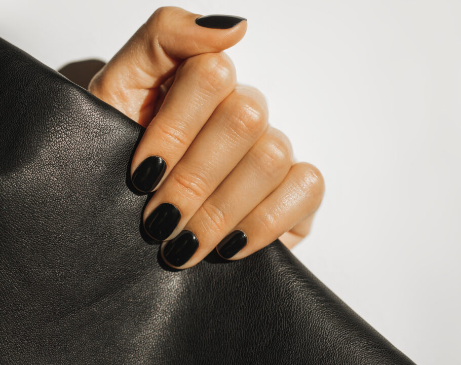 hand with black nails holding clutch