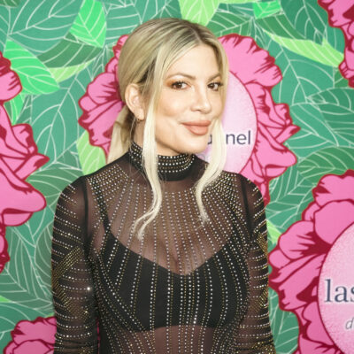 Tori Spelling posing in front of a colorful background