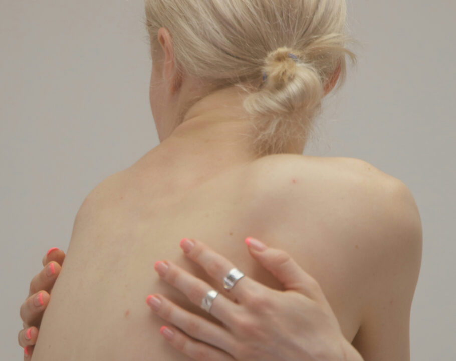 back view of blonde-haired woman with arms and hands crossed over her back