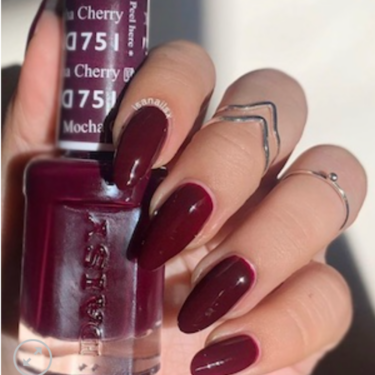 A woman's hand with cherry mocha nails holding DND cherry mocha nail polish container