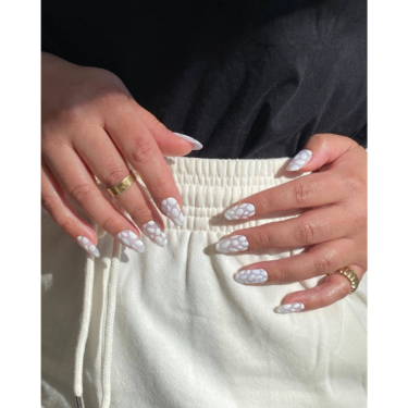 A close-up of hands featuring an all white crocodile-themed nail art manicure.