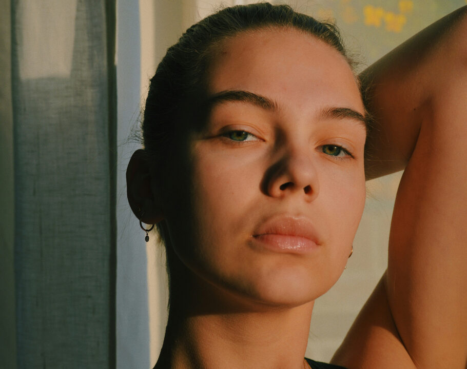 woman with arm up over her head in low sunlight