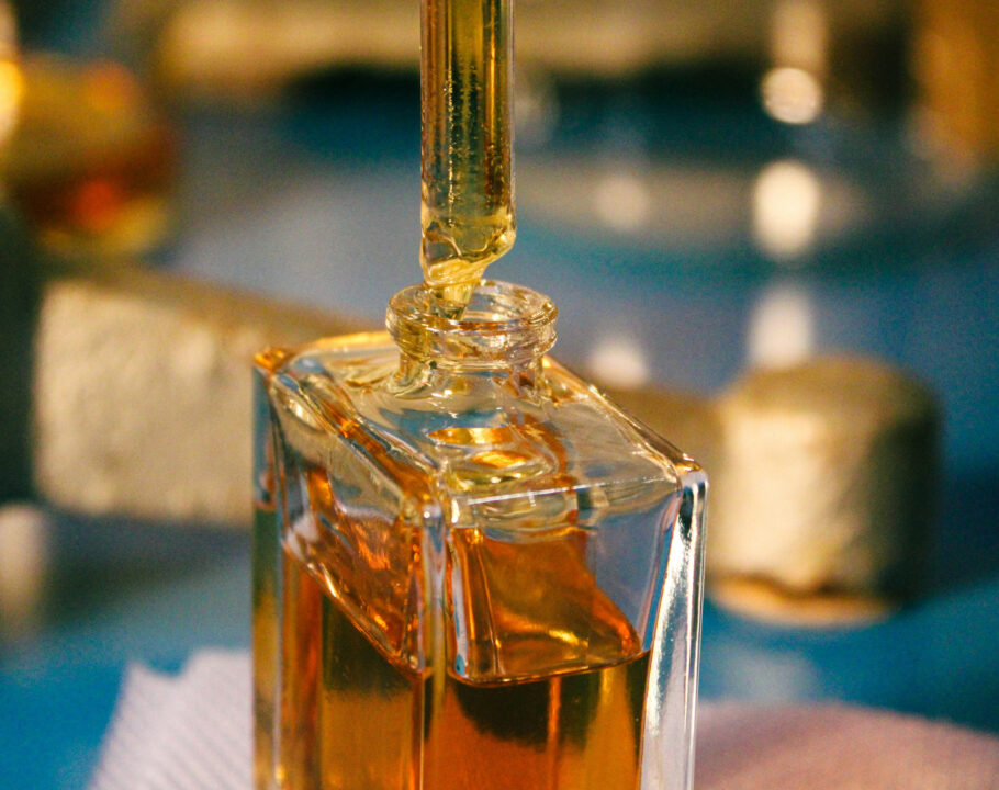 a bottle of liquid with dropper sitting on top of a table