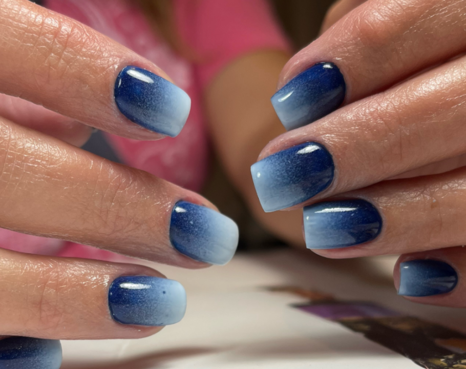 A close up of a woman's hands with a denim nails design