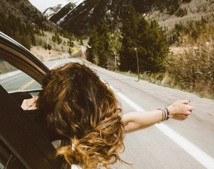 woman in car with hand out the window