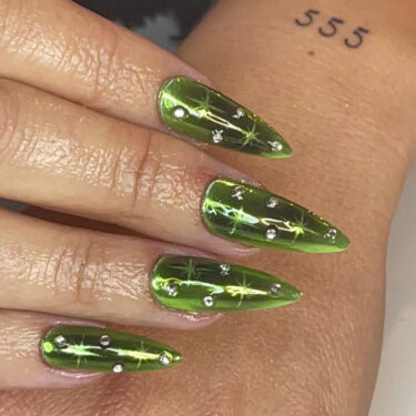 green chrome nails with stars and rhinestones